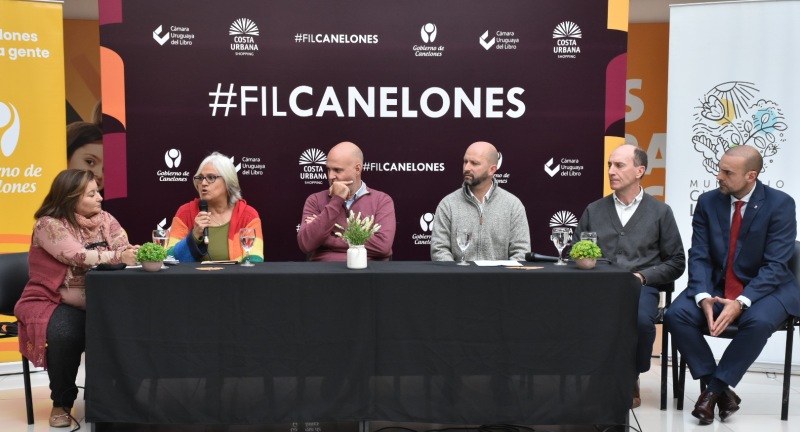 mesa de oradores. Derecha a izquierda: Alcaldesa del Municipio Ciudad de la Costa, Sonia Misirian, Vicepresidenta de la Cámara Uruguaya del Libro Lourdes Pérez, Secretario General de la Intendencia de Canelones  Francisco Legnani, Director General de Cultura Sergio Machín, Gerente Costa Urbana Shopping Alberto Gossweiler, Secretario General de la Intendencia de San José, Sebastián Ferrero