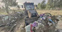 Retroexcavadora cargando basura  